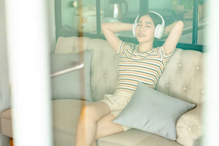 woman sitting on sofa listening to music