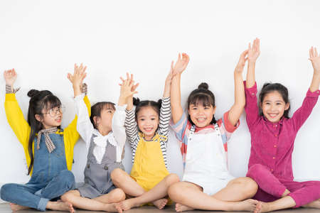 five little girls raising their handsの写真素材