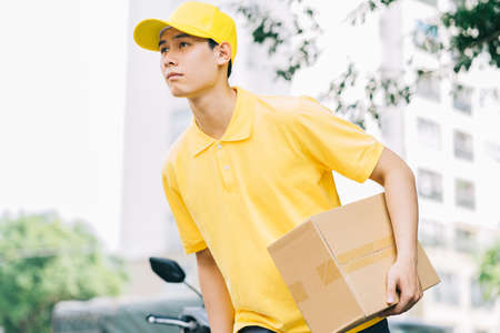 Asian delivery people are running on the road to deliver goods to customersの写真素材