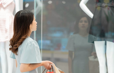 Young girl is watching clothes outside the storeの写真素材