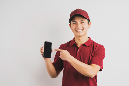 Delivery man holding phone in backgroundの写真素材