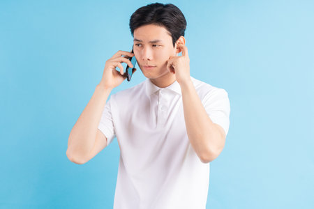 Young hipster man talking on phone against color backgroundの写真素材