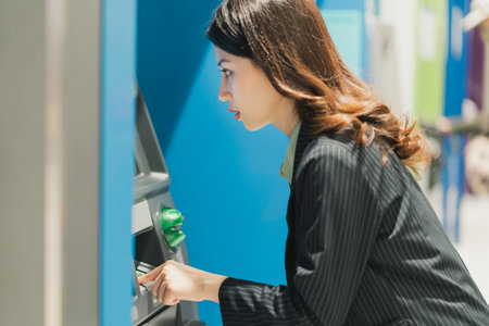 Young girl withdrawing money at the mallの写真素材