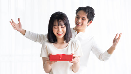 Asian boyfriend gives gifts to his girlfriend on Valentine's Dayの写真素材