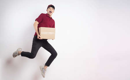 Portrait of a male delivery man holding a cargo box, backgroundの写真素材