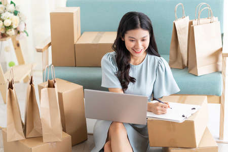 Young asian girl sitting at home selling online