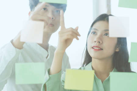 Young Asian business couple working together, completing the assigned work