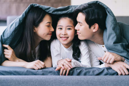 Happy Asian family portrait with mother, father and daughterの写真素材