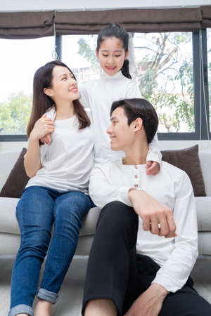 Portrait of young Asian family consisting of parents and daughterの写真素材