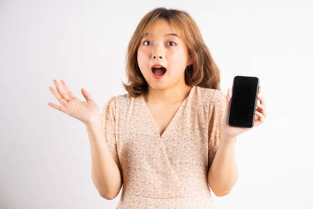Young asian girl holding phone with expressions, gestures on backgroundの写真素材