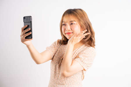 Young asian girl holding phone with expressions, gestures on backgroundの写真素材