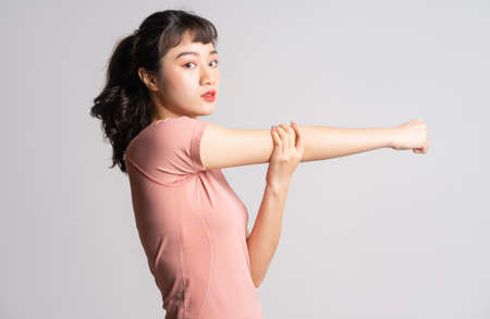 Young Asian woman doing exercise on white backgroundの写真素材