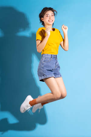 Young Asian girl posing on blue background
