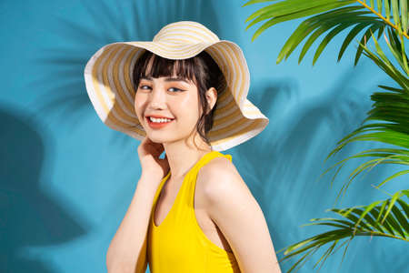 Beautiful Asian woman wearing yellow jumpsuit on blue background and, summer conceptの写真素材