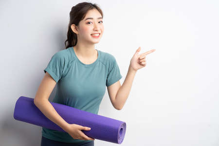 Young Asian woman doing exercise on white backgroundの写真素材