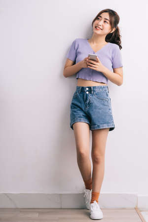 Young Asian woman using smartphone on white backgroundの写真素材