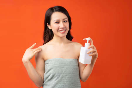 Beautiful young Asian girl taking skin care with a cheerful expressionの写真素材