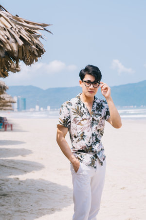 Young Asian man walking on the beachの写真素材