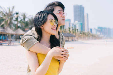 Young Asian couple enjoying summer vacation on the beachの写真素材