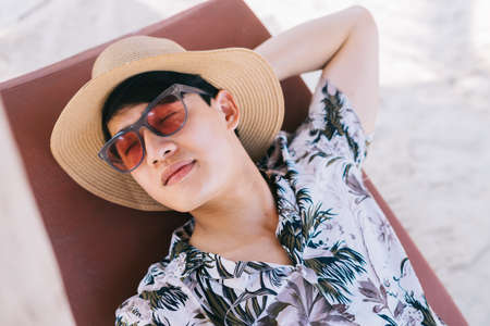 Asian man lying resting on the beachの写真素材