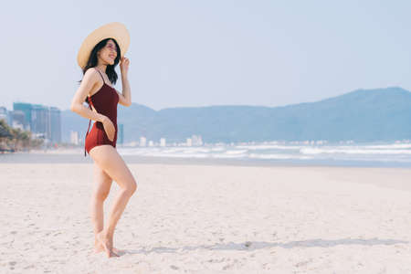 Beautiful young asian woman in swimwear relaxing at the beach during summer vacationの写真素材