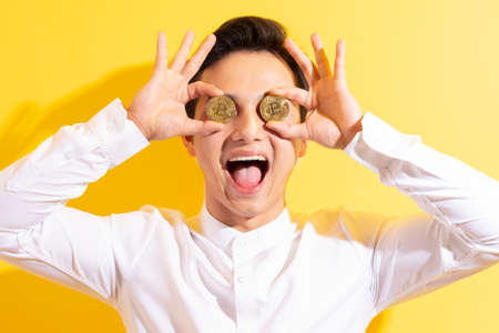 Asian businessman holding bitcoin in his hand wite happy face