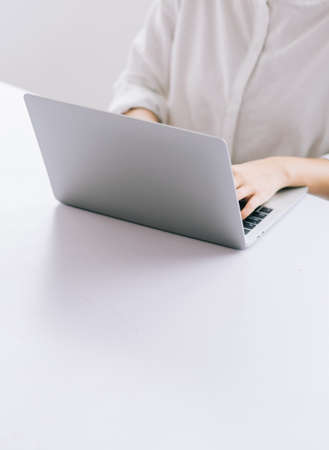 Cropped image of Asian business woman using laptop