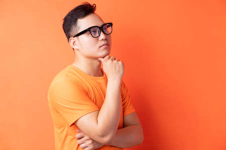 Asian man standing in thought