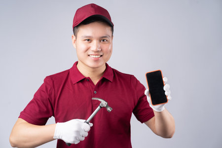 Image of Asian repairman on gray backgroundの写真素材