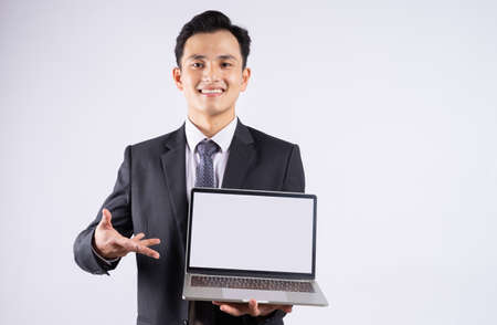 Young Asian businessman using laptop on white backgroundの写真素材
