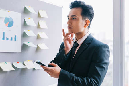 Asian business people are planning a business next to the plan boardの写真素材