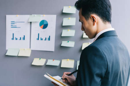 Asian business people are planning a business next to the plan boardの写真素材