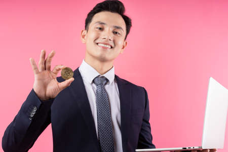 Image of young Asian businessman on pink background