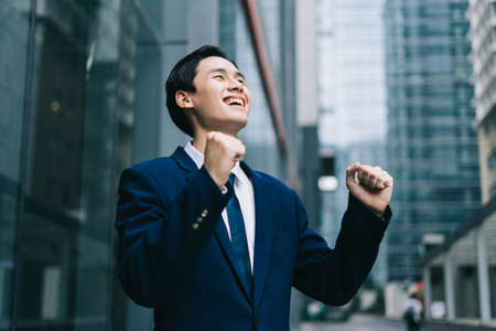 Image of Young asian businessman with glass building backgroundの写真素材
