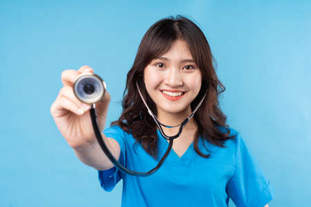 Young Asian female doctor need stethoscope laughing happily on backgroundの写真素材