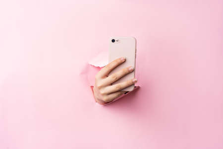 Woman arm holding phone on backgroundの写真素材
