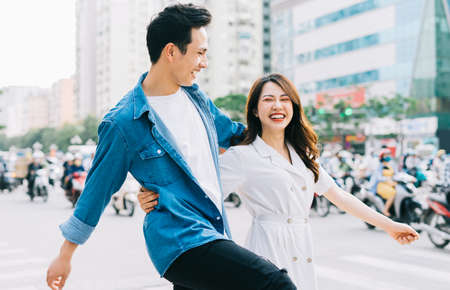 Young Asian couple walking on the streetの写真素材