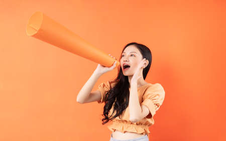 Asian woman using a paper speaker, Concept announcesの写真素材