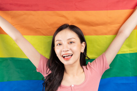 Young Asian woman holding rainbow flag to support LGBTQ+ communityの写真素材