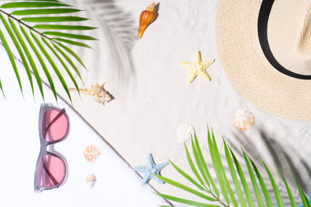 Summer back ground with seashell, sunglasses and hat on the sand