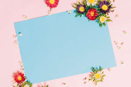 The blue paper is placed on a pink background with flowers aroundの写真素材