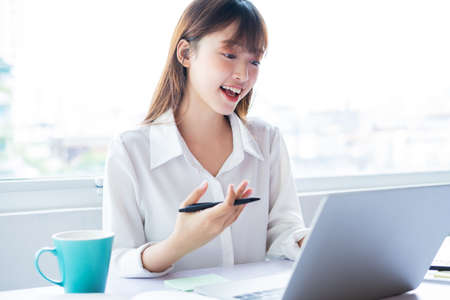 Beautiful young asian businesswoman is working online with a good mood