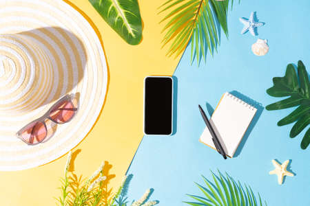 Summer background with phone, note, hat and sunglassesの写真素材