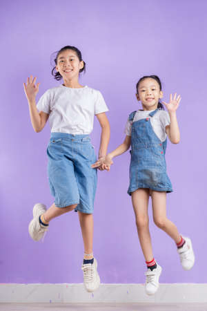 Portrait of two Asian girls on purple backgroundの写真素材