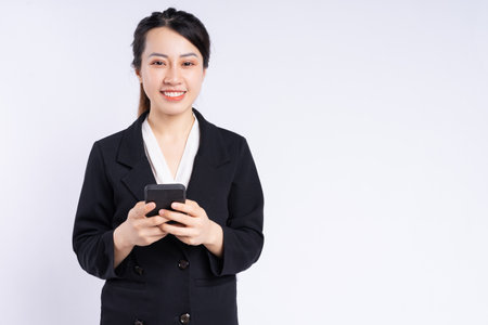 Young Asian businesswoman using smartphone on white backgroundの写真素材
