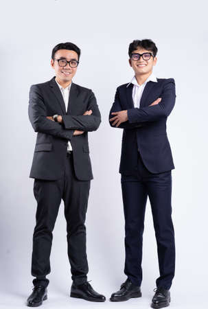 Two Asian businessmen jumping on white background