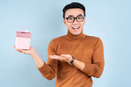 Asian man wearing winter clothes on blue background