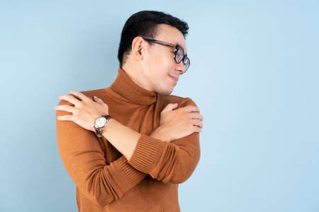 Asian man posing on blue backgroundの写真素材