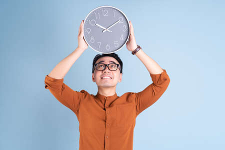 Young Asian man holding white board on blue background