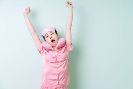 Young Asian woman wearing pajamas on green backgroundの写真素材